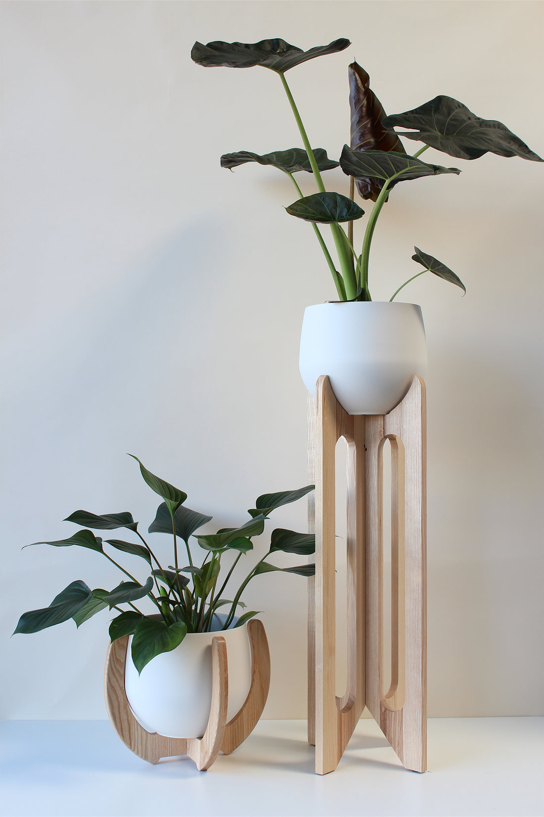 arches and nested plant stands by Kandis Cottage styled against white wall with houseplants