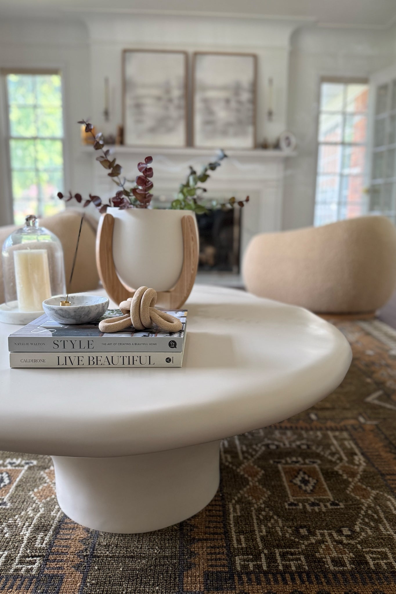 The Nested Plant Stand on a white, modern coffee table with other decorative elements like coffeetable books and incense.