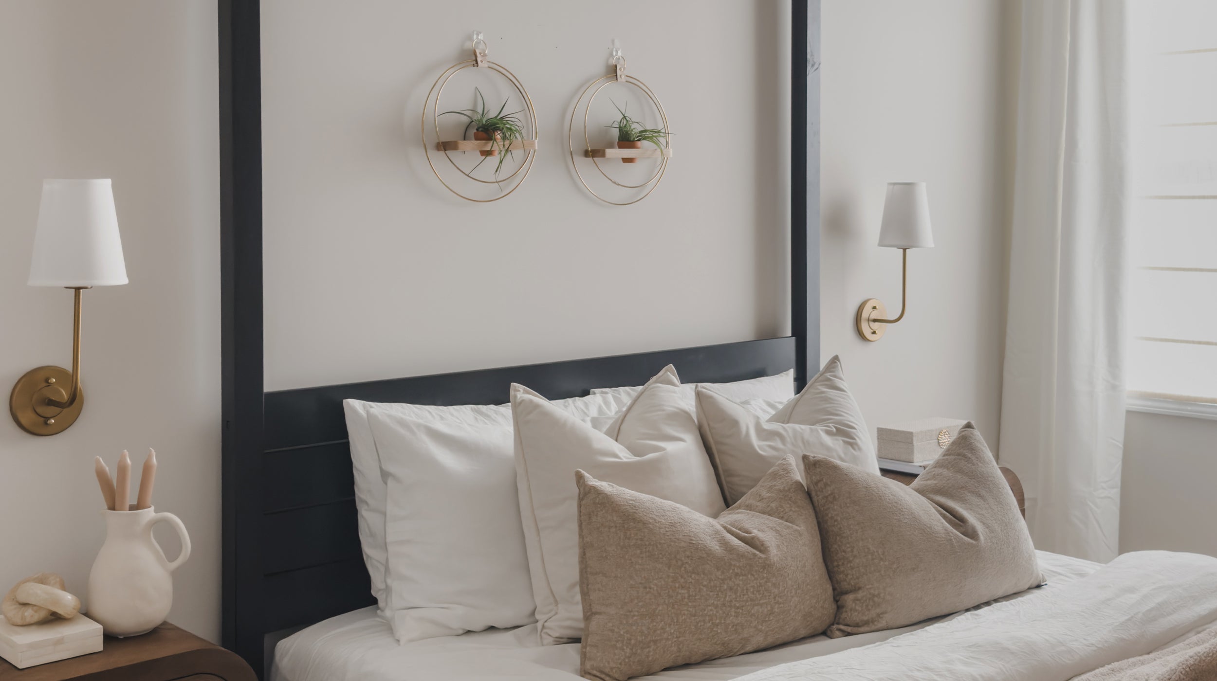 two wall mounted plant shelves with gold circular rings and terracotta pots in a bedroom