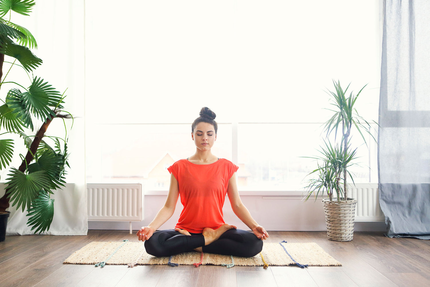 woman doing yoga in modern room with houseplants